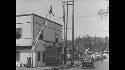 A man hanging from a boom barrier.